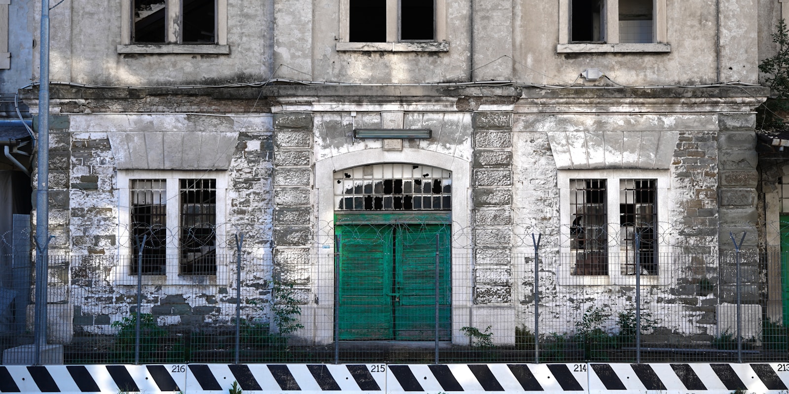 Trieste white concrete building with green wooden door